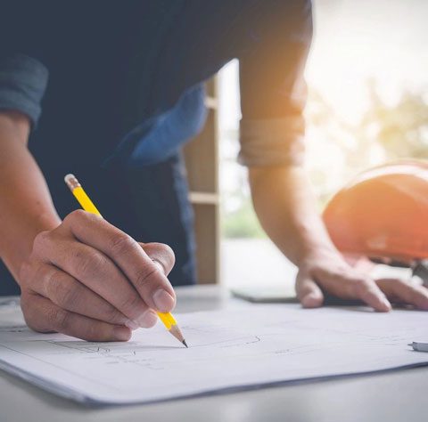 A person writing on paper with a pencil