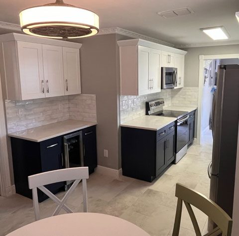 A kitchen with white cabinets and black doors