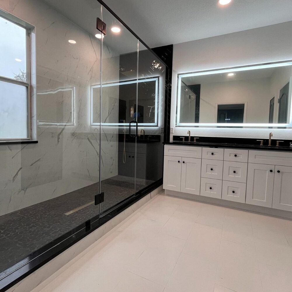 A bathroom with a large mirror and a glass shower.